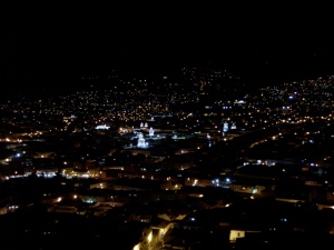 A view of Quito from the restaurant balcony.  The spires of several churches are illuminated and stand above the rooftops of the other buildings.